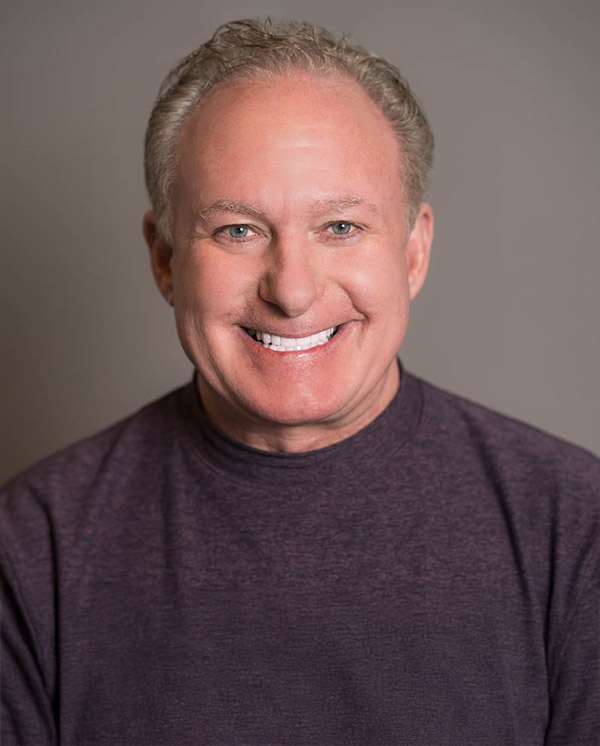 Wayne Goshkarian smiling and wearing a dark grey shirt